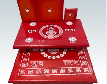 May include: A red wooden altar set with a swastika design and the words "Shubh Laabh" in white. The set includes a large base, a smaller top platform, and two smaller side platforms. The base is decorated with a swastika pattern and the words "Shubh Laabh" in white. The top platform is decorated with a swastika pattern and the words "Shubh Laabh" in white. The side platforms are decorated with a swastika pattern.
