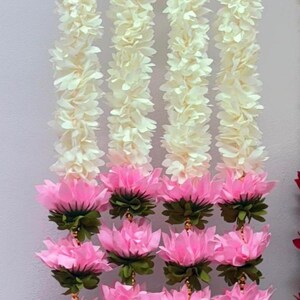 Op de afbeelding: Verticale afbeelding van meerdere decoratieve slingers. Elke slinger wisselt af tussen witte, gerimpelde bloemsecties en secties met roze lotusbloemen en groene bladeren. Geschikt voor feestelijke gelegenheden.