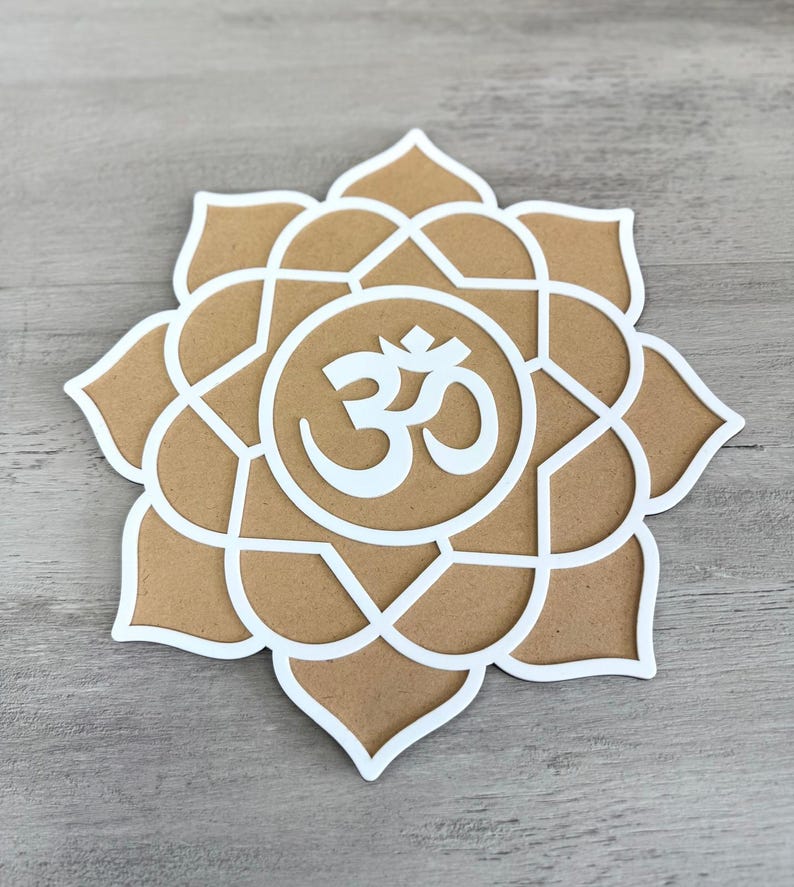 May include: A white om symbol is centred in a brown mandala with a white outline. The mandala is shaped like a flower with eight petals.