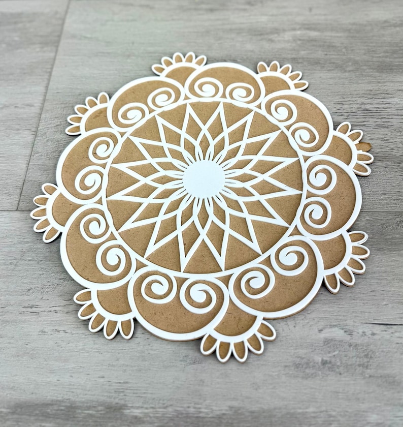 May include: A white mandala design on a brown background. The mandala has a circular pattern with intricate details.