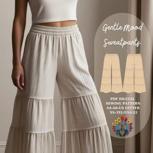 May include: Cream-coloured, wide-leg sweatpants with a tiered design. The trousers have an elastic waistband and vertical ribbed texture. The image also includes a sewing pattern diagram and text that reads "Gentle Mood Sweatpants."