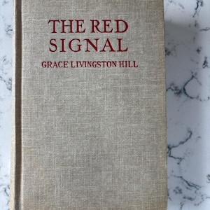 Antique 1919 novel “The Red Signal” by Grace Livingston Hill. Linen texture with deep red lettering. Includes inscription from 1958