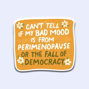 May include: A sticker with a mustard-yellow background and white border. The text reads: "CAN'T TELL IF MY BAD MOOD IS FROM PERIMENOPAUSE OR THE FALL OF DEMOCRACY." Small white flowers with yellow centers are in each corner.