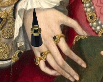 May include: A black ring display cone with a gold ring featuring a black square stone set in a flower design.