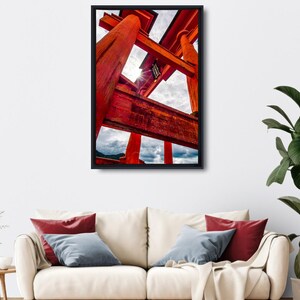 Könnte beinhalten: Gerahmter Druck eines leuchtend roten japanischen Torii-Tors vor einem bewölkten Himmel. Das Kunstwerk fängt die architektonischen Details des Tors aus einer niedrigen Perspektive ein. Der Druck wird über einem cremefarbenen Sofa präsentiert.