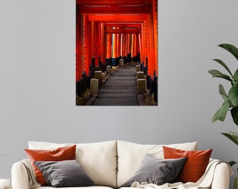 May include: A framed print of a pathway lined with vibrant orange torii gates. The gates create a tunnel effect, leading the eye towards the vanishing point. The pathway is made of stone steps, and the image is displayed above a white sofa with orange and gray pillows.