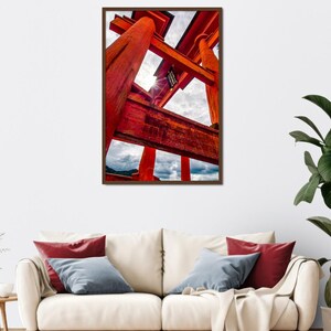 Könnte beinhalten: Ein gerahmter Druck eines leuchtend roten japanischen Torii-Tors vor einem bewölkten Himmel. Die Holzstruktur des Tors ist detailliert, mit sichtbarer Maserung und Textur. Das Kunstwerk wird über einem cremefarbenen Sofa mit dekorativen Kissen ausgestellt.