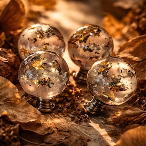 May include: A trio of cream-glazed ceramic mugs with a speckled finish. Each mug is adorned with a hand-painted floral design in blue, green, and yellow hues. The mugs have a simple, rounded form and a comfortable handle.