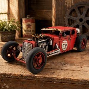 May include: A red metal hot rod model car featuring a prominent silver grille, exposed engine components with four exhaust pipes, and black tires. The side of the vehicle displays a circular white decal with the number 79 and text in black.