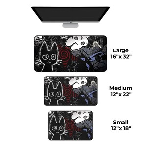 May include: Black desk mats with a cartoon cat and a white mask design. The mats are available in three sizes: large (16" x 32"), medium (12" x 22"), and small (12" x 18"). A computer monitor is above the mats.