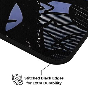May include: Black mousepad with a graphic design and stitched black edges. The text on the image reads "Stitched Black Edges for Extra Durability". The mousepad has a black border.