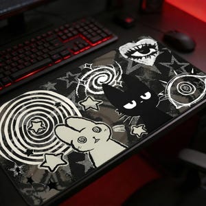 Puede incluir: Alfombrilla de ratón rectangular en blanco y negro con un diseño caprichoso. Presenta un gato negro, un conejo blanco, estrellas y patrones arremolinados. Diseñada para usar con un ratón de ordenador, combina estética y funcionalidad.