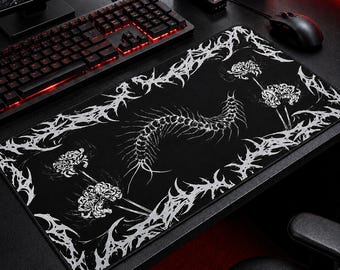 May include: Black rectangular mouse pad with a white, stylized design. The design features a central spine-like element, floral accents, and a decorative border. The mouse pad is on a black desk with a keyboard and mouse.