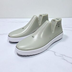 Op de afbeelding: Twee grijze schoenmallen met witte zolen. Elke mal is gemarkeerd met het nummer "43" en de tekst "AC SPORT". Deze mallen worden gebruikt om schoenen te vormen en worden getoond op een wit marmeren oppervlak.