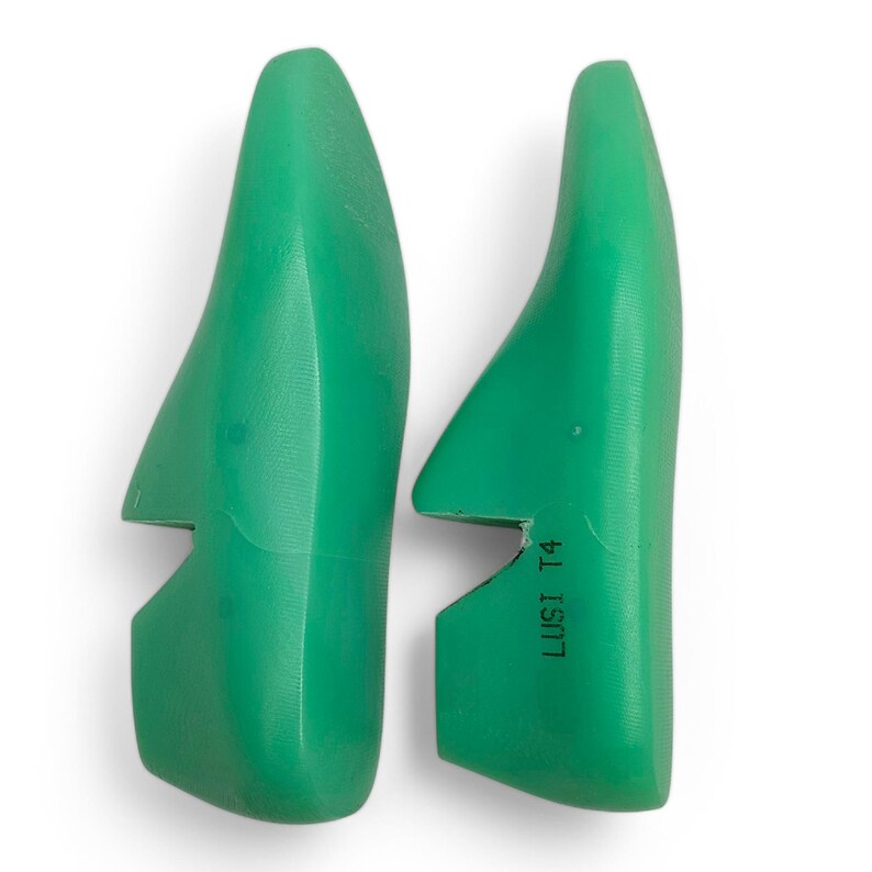 May include: Two green plastic shoe lasts with the text "LUSI T4" printed on one of the lasts.