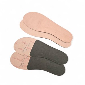 Peut inclure: Quatre semelles int&eacute;rieures de chaussures. Deux sont de couleur beige clair et deux sont noires. Les semelles noires portent le texte "Texon Stride" et d'autres textes. Les semelles sont con&ccedil;ues pour &ecirc;tre ins&eacute;r&eacute;es dans les chaussures.