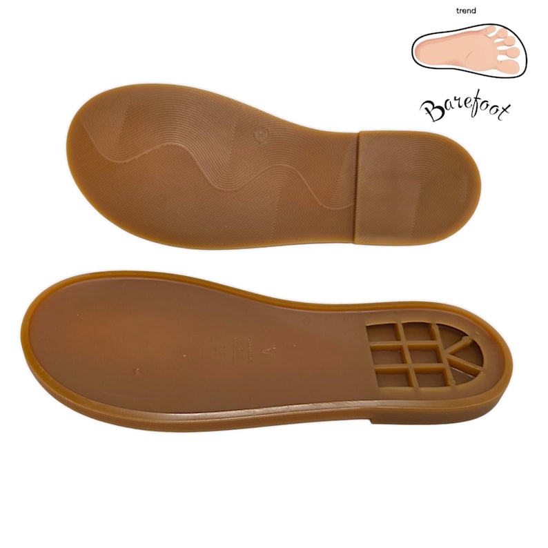 May include: Two brown shoe soles, one above the other, are displayed against a white background. The soles are made of a rubber-like material. The top sole has a wavy pattern, while the bottom sole has a grid-like design near the heel. The word "Barefoot" is written in cursive.