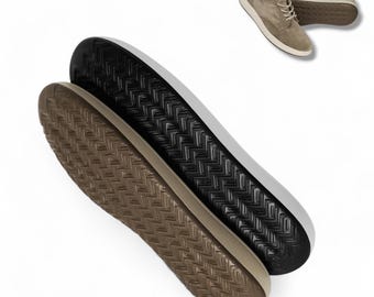 May include: A pair of casual shoes with a light brown suede upper and white soles. The soles are visible, showing a black and brown textured pattern. The shoes are designed for everyday wear.