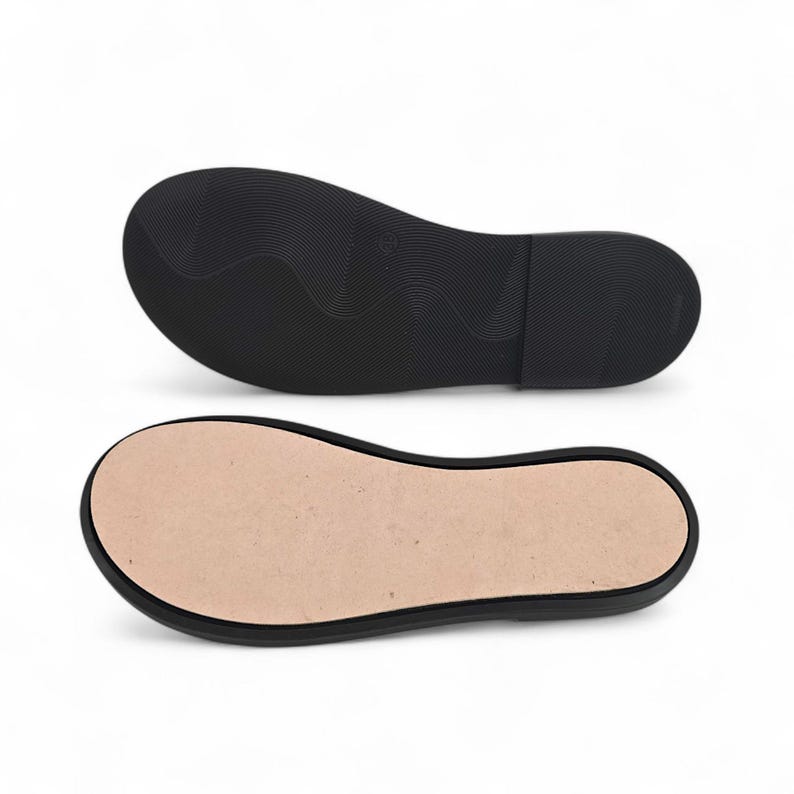 Peut inclure: Deux semelles de chaussures noires, l'une montrant le dessous textur&eacute; et l'autre l'int&eacute;rieur. La semelle inf&eacute;rieure pr&eacute;sente un motif ondul&eacute;, tandis que la semelle int&eacute;rieure est de couleur beige clair. Les semelles sont con&ccedil;ues pour les chaussures.