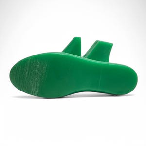 K&ouml;nnte beinhalten: Ein Paar gr&uuml;ne Schuhleisten, die zum Formen von Schuhen w&auml;hrend des Herstellungsprozesses verwendet werden.
