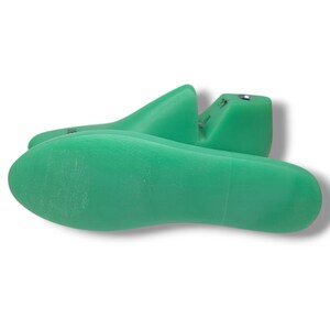 May include: A pair of green plastic shoe trees. The shoe trees are designed to help maintain the shape of shoes.