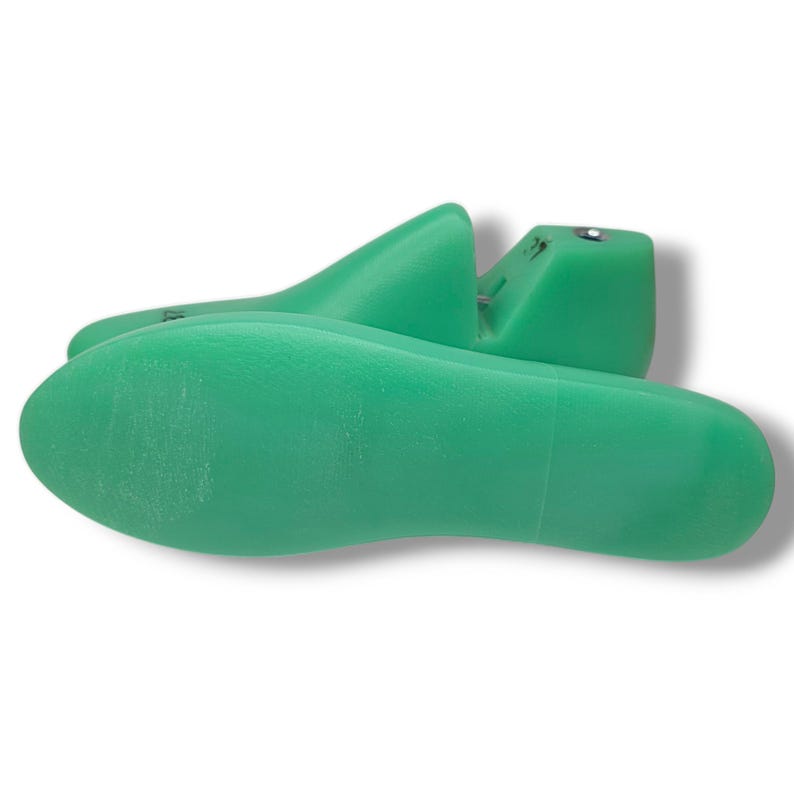 May include: A pair of green plastic shoe trees. The shoe trees are designed to help maintain the shape of shoes.
