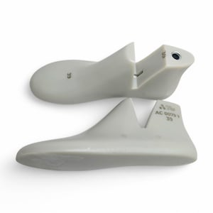 May include: A pair of white plastic shoe forms, one with the size 39 printed on it and the other with the size 39 and the text "AC 0079 Y" printed on it.