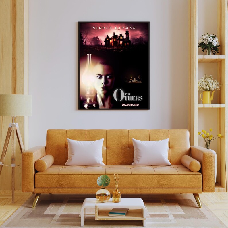 May include: A movie poster for the film "The Others" starring Nicole Kidman. The poster features a woman with dark hair and a white dress standing in front of a large, old house. The text on the poster reads "The Others" and "We Are Not Alone".