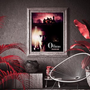 May include: A movie poster for the film "The Others" starring Nicole Kidman. The poster features a woman holding a lantern in a dimly lit room. The text on the poster reads "The Others" and "We are not alone".