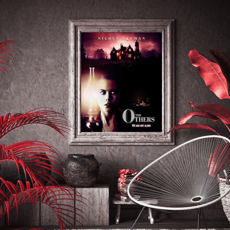 May include: A movie poster for the film "The Others" starring Nicole Kidman. The poster features a woman holding a lantern in a dimly lit room. The text on the poster reads "The Others" and "We are not alone".