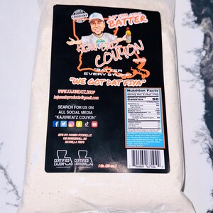 May include: A white bag of Cajun batter mix with a black label that says "Cajuneatz Coupon" and "We Got Dat Fiya". The bag is 1 lb (18 oz) and is certified Cajun and Louisiana.