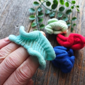 May include: Four colorful hair scrunchies in blue, red, green, and light blue. The scrunchies are made of a soft, stretchy fabric and are perfect for holding hair in place.