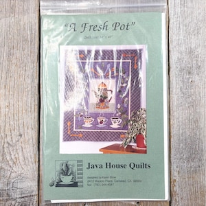 May include: A quilt pattern titled "A Fresh Pot" featuring a teapot and teacups design. The quilt size is 34" x 40". The package also includes the Java House Quilts logo and contact information.