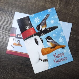 sneeuwpop hoofd fijne feestdagen kerstkaart vogels spreeuwen wortel neus neergestreken wenskaart stationair vintage nieuwe oude voorraad sneeuwvlokken