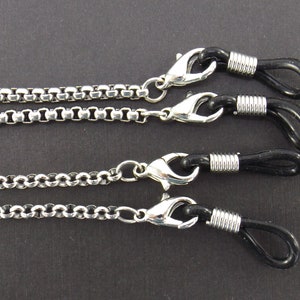 May include: Three silver eyeglass chains with black rubber ends. Each chain has a different style of link.