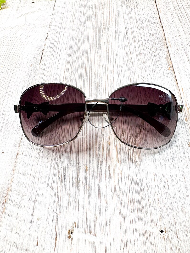 Gafas de sol cuadradas negras de gran tamaño: detalle de lazo, lentes moradas imagen 6