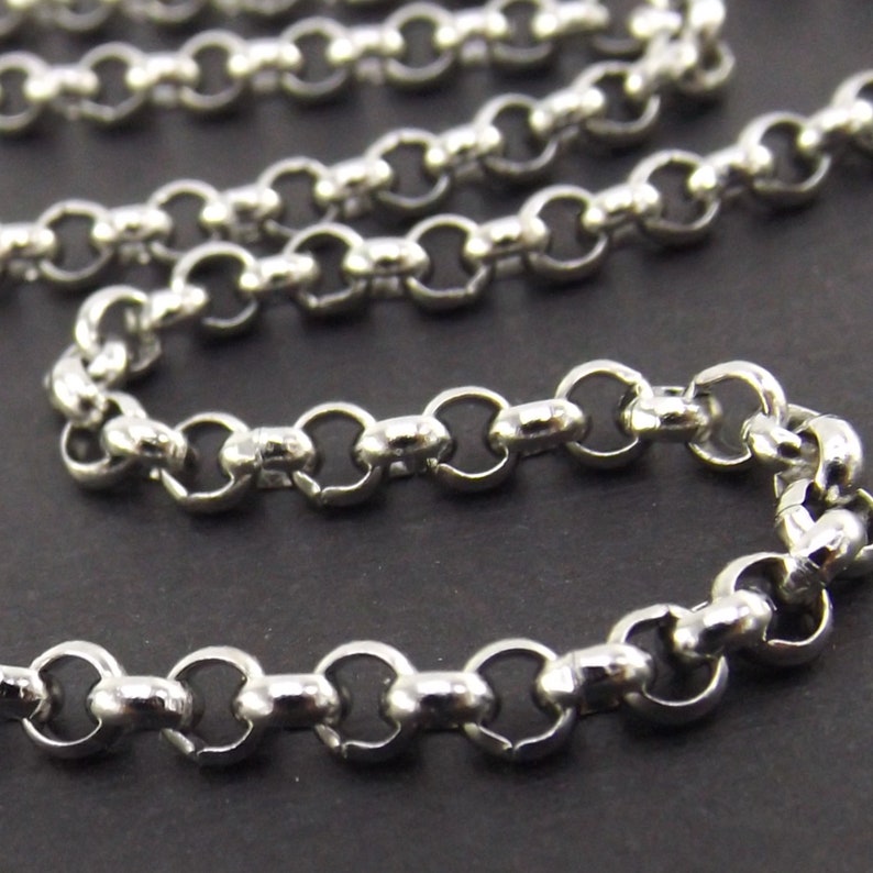 May include: A silver chain with a round, smooth link design. The chain is made of metal and has a polished finish.