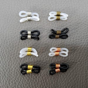 May include: Eight pairs of eyeglass temple tips, each pair featuring a different color combination of black, white, gold, and copper. The tips are designed to be attached to the ends of eyeglass temples.