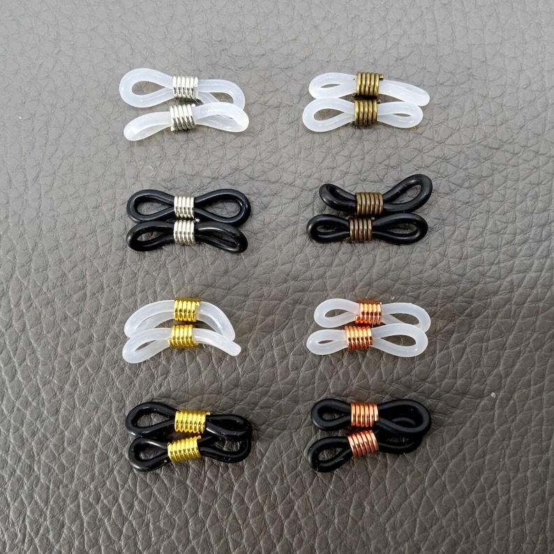 May include: Eight pairs of eyeglass temple tips, each pair featuring a different color combination of black, white, gold, and copper. The tips are designed to be attached to the ends of eyeglass temples.