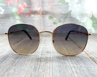 Gafas de sol redondas extragrandes: Montura de metal dorado claro, lentes con degradado azul.