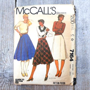 May include: Vintage McCall's sewing pattern featuring illustrations of women's skirts and tops. The pattern cover includes the text "McCall's", "Learn to Sew for Fun", and the pattern number 7164. The waist size is 26 1/2 inches.