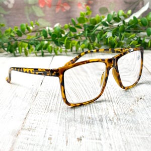 May include: A handmade, wooden cutting board with a natural finish. The board features a live edge on one side and a rectangular shape. It is approximately 18 inches long and 12 inches wide.