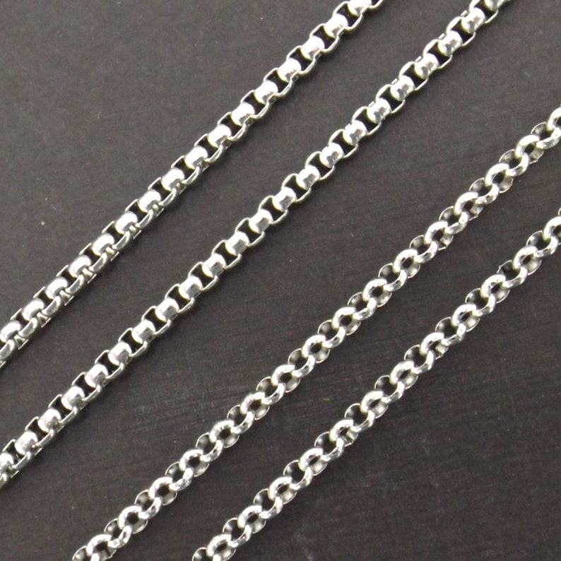 May include: Three silver chains of different thicknesses, all with a box chain design.