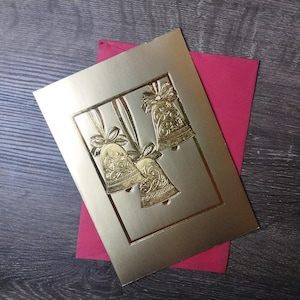 Tarjeta navideña con campanas de papel dorado y buenos deseos para el año nuevo, además de tarjeta de felicitación de la empresa estadounidense Marl, hecha en EE. UU.