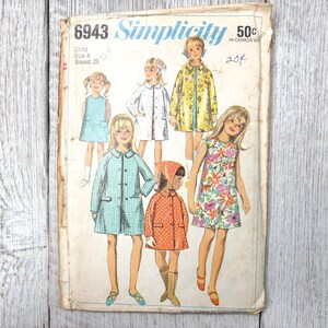 Può includere: Cartamodello Simplicity vintage 6943 per bambina taglia 4, con illustrazioni di abiti e cappotti per bambini. La busta del modello è invecchiata, con testo che indica la taglia e il prezzo.