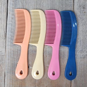May include: Four plastic combs in different colors: peach, cream, pink, and blue. Each comb has a rounded handle with a hole at the bottom.