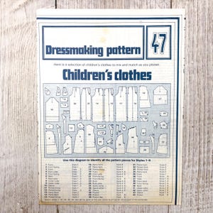 Może przedstawiać: Wzór krawiecki w stylu vintage dla odzieży dziecięcej, z różnymi elementami wzoru i diagramami. Niebiesko-biała strona zawiera tekst "Dressmaking pattern" i "Children's clothes."