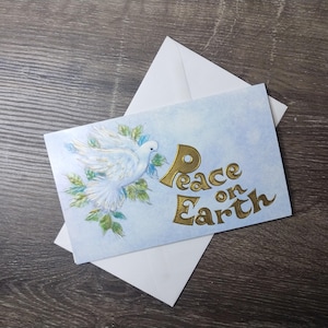 vrede op aarde kerstkaart vintage wenskaart nieuw oude voorraad witte duif blauw goud welwillendheid jegens mannen vakantie beroemde creatieve studio's