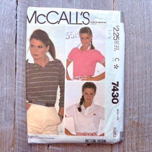 May include: A vintage McCall's sewing pattern envelope. The front shows images of polo shirts in different colours. The envelope displays the McCall's logo, pattern number 7430, and price information. The pattern is for a small size.