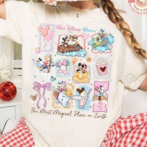 May include: Cream-colored t-shirt featuring a colorful collage of Disney characters and attractions. The design includes Mickey and Minnie Mouse, Dumbo, and other characters, with the text "Walt Disney World" and "The Most Magical Place on Earth."